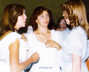 Three young women at a high school graduation.
